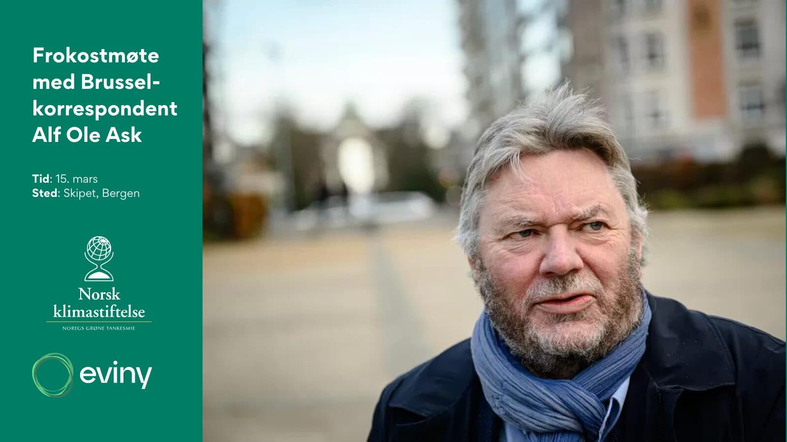 En mann med grått hår og skjegg står utenfor, litt utenfor midten til høyre, med et fokusert uttrykk i ansiktet. bakgrunnen er uskarp, med utendørs landskap og bygninger. til venstre.